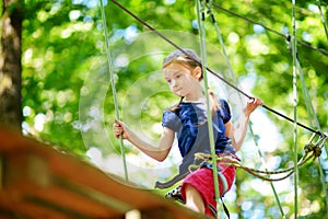 Adorable little girl enjoying her time in climbing adventure park