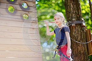 Adorable little girl enjoying her time in climbing adventure park