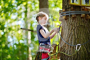 Adorable little girl enjoying her time in climbing adventure park