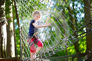 Adorable little girl enjoying her time in climbing adventure park