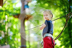 Adorable little girl enjoying her time in climbing adventure park