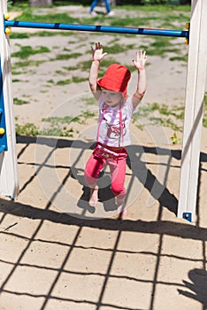 Adorable little girl enjoying her time in climbing adventure park on warm and sunny summer day. Summer activities for young kids.