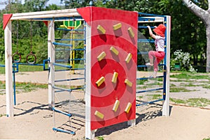 Adorable little girl enjoying her time in climbing adventure park on warm and sunny summer day. Summer activities for young kids.