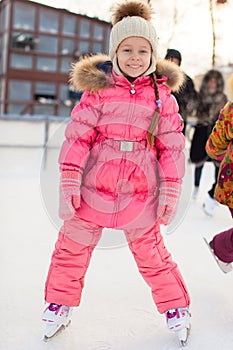 Adorable little girl enjoying skating at the ice-rink