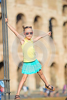 Adorable little girl in front of Colosseum in Rome, Italy. Kid spending childhood in Europe