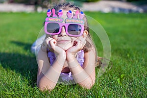 Adorable little girl in Happy Birthday glasses