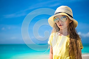 Adorable little girl in hat at beach during caribbean vacation