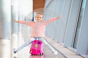 Adorable little girl having fun in airport sitting
