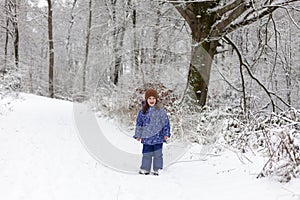 Adorable little girl having fun in beautiful winter park. Cute child playing outdoors. Winter activities for kids