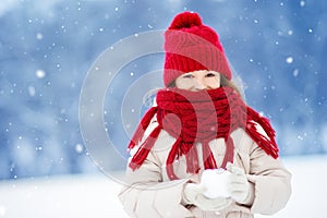 Adorable little girl having fun in beautiful winter park. Cute child playing in a snow.