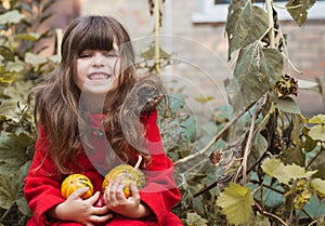 Adorable little girl having fun on a pumpkin patch on beautiful autumn day outdoors