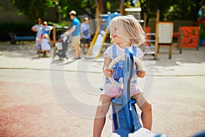 Adorable little girl having fun on seesaw