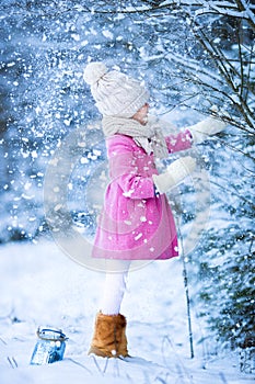 Adorable little girl having fun in the snow on
