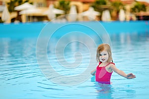 Adorable little girl having fun in a swimming pool