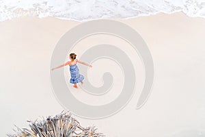 Adorable little girl having a lot of on white tropical beach. View from above of a deserted beach with turquoise water