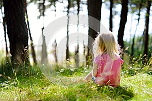 Adorable little girl hiking in the forest on summer day