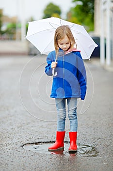 Adorable little girl holding white umbrella