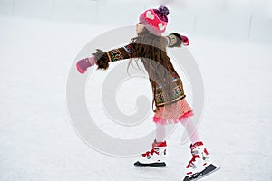 Adorable little girl on the ice rink