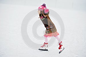 Adorable little girl on the ice rink