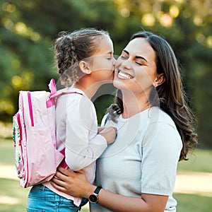 Adorable little girl kissing her mother on the cheek outside. Cute mixed race child saying goodbye to parent outside