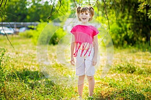 Adorable little girl laughing in a meadow - happy