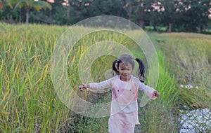 Adorable little girl laughing in a meadow - happy girl at sunset