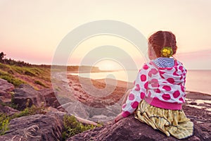 Adorable little girl looking at the sunset