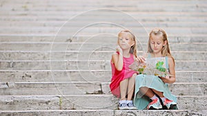 Adorable little girl looking at touristic map on steps in Italy. Happy toodler kids enjoy italian vacation holiday in