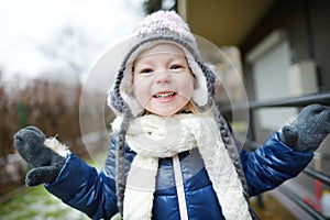 Adorable little girl making funny faces outdoors