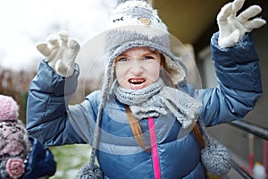 Adorable little girl making funny faces outdoors