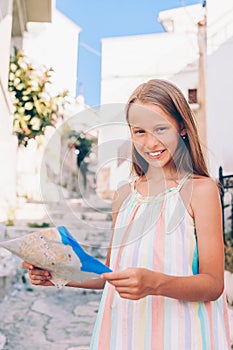 Adorable little girl with map of european city outdoors