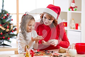 Adorable little girl and mother baking Christmas cookies