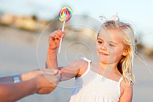 Adorable Little Girl Picking out Lollipop Outside