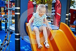 Adorable little girl on playground on a sunny day