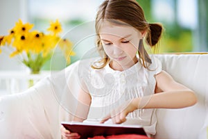 Adorable little girl playing with a digital tablet