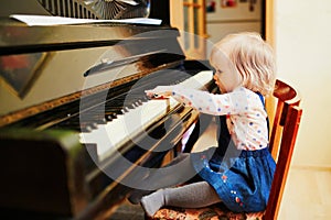 Adorable little girl playing piano