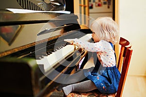 Adorable little girl playing piano