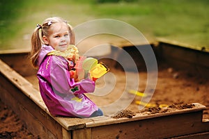 Adorable little girl playing in a sandbox