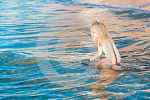 Adorable little girl playing in the sea on a beach