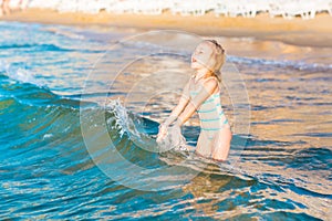 Adorable little girl playing in the sea on a beach photo
