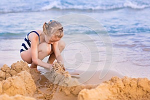 Adorable little girl playing at the seashore