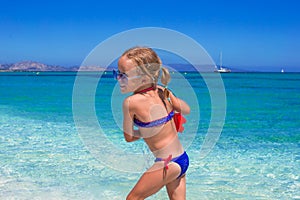 Adorable little girl playing with toy on beach photo