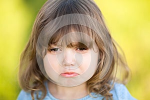 Adorable little girl with sad expression of her face, going to cry