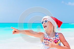 Adorable little girl in Santa hat during Christmas beach vacation