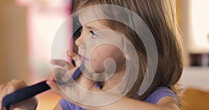 Adorable little girl sitting and playing with a pencil