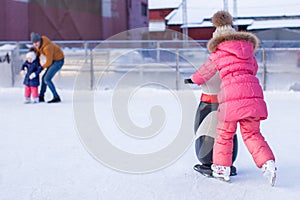 Adorable little girl skating on the ice-rink