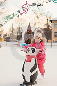 Adorable little girl skating on the ice-rink