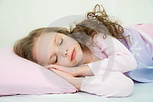 Adorable little girl sleeping in her bed