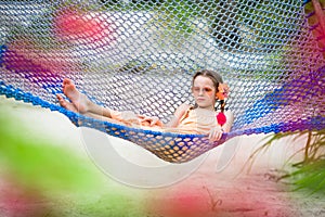 Adorable little girl on summer vacation relaxing in hammock