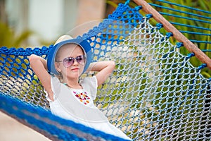 Adorable little girl on summer vacation relaxing in hammock